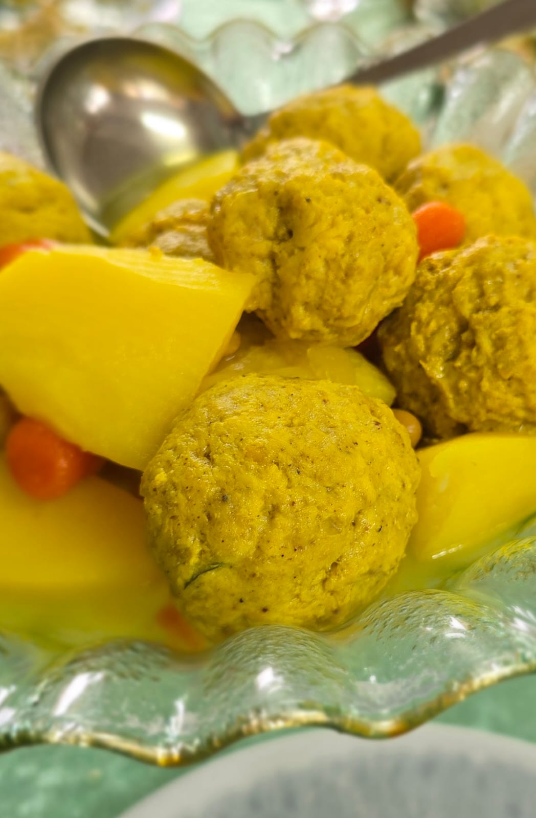 גונדי — כדורי עוף בקמח חומוס בקערת זכוכית עם תפוחי אדמה וגזר